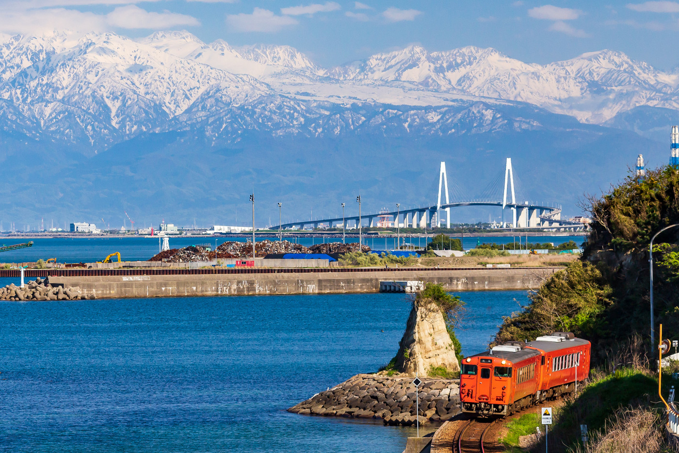 富山・氷見線と立山連峰・新湊大橋