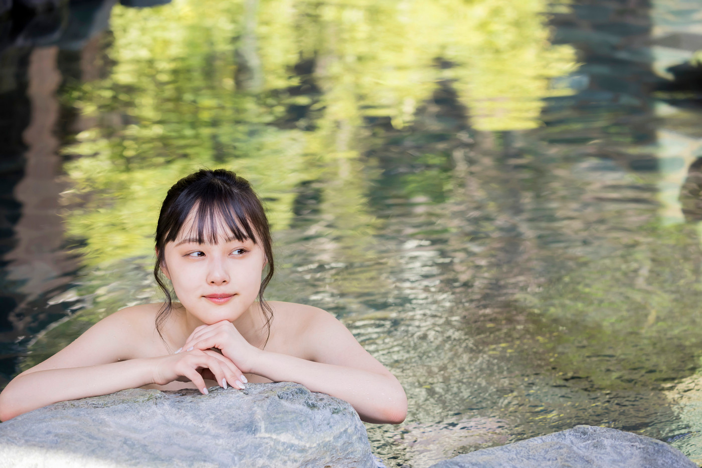 のんびり露天風呂に入る若い女性