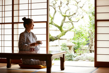 A young woman in a yukata relaxing at ryokan