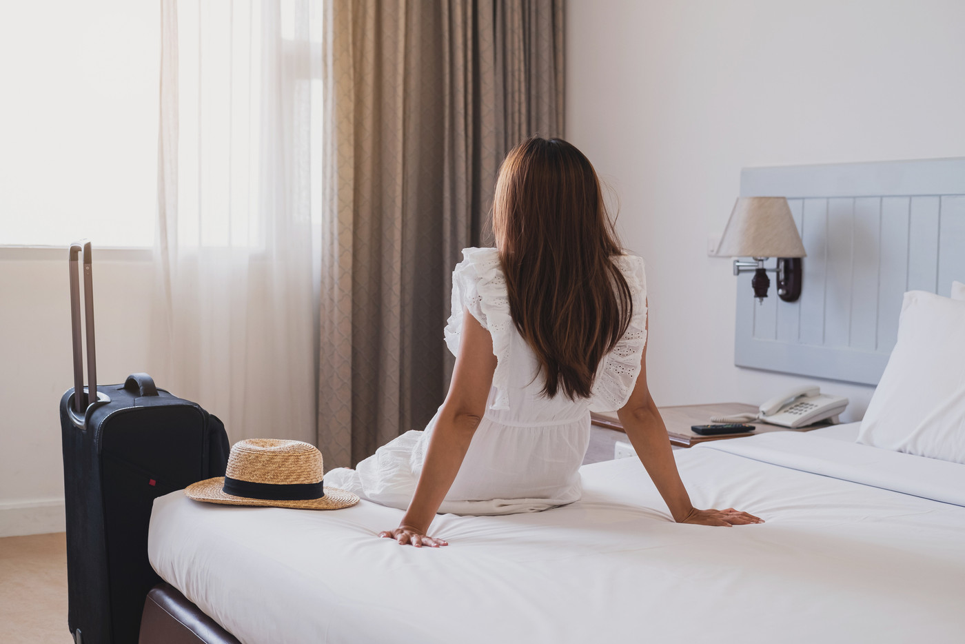 Young asian woman traveler with luggage sitting
