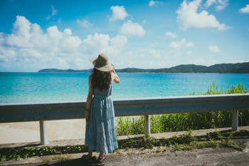 Back view of a woman in a one-piece dress with the ocean, Tropical Beach Resort, Amami Oshima