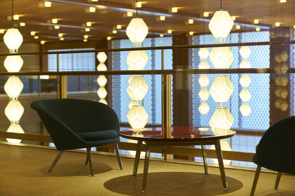 Hand holding cup of cappuccino on warm scarf