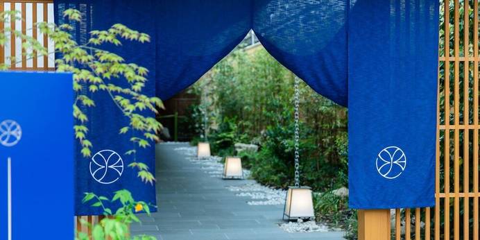 ONSEN RYOKAN YUEN SHINJUKU(温泉旅館 由縁 新宿)（東京都 旅館）：深いブルーが美しい、和モダンなのれんが目印。石畳のアプローチが旅情をそそり、一歩踏み入れた瞬間から都会の喧騒を忘れられる。 / 1