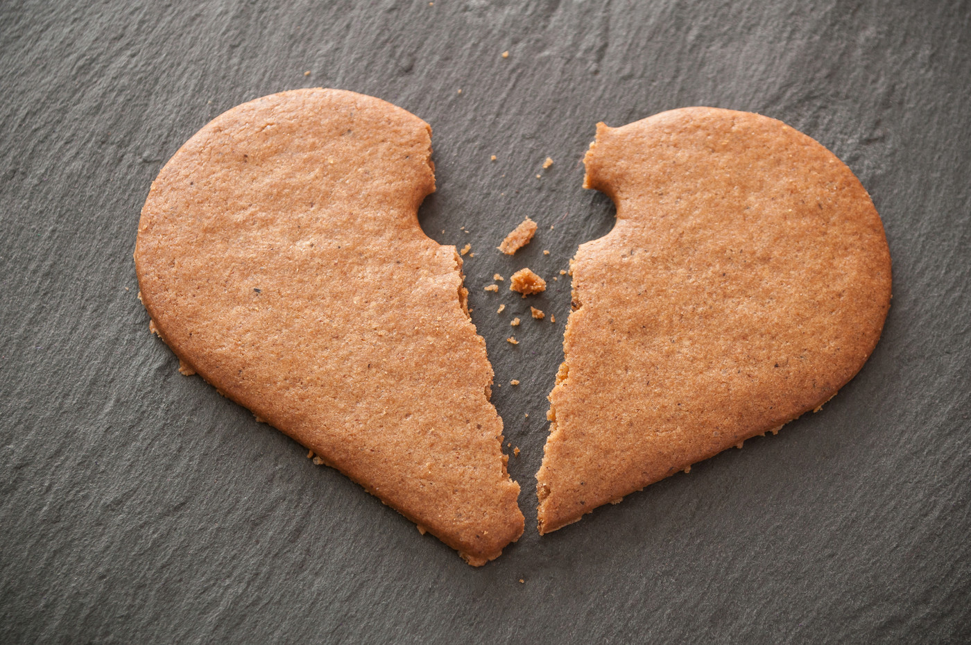 shaped broken heart biscuit on chalkboard 