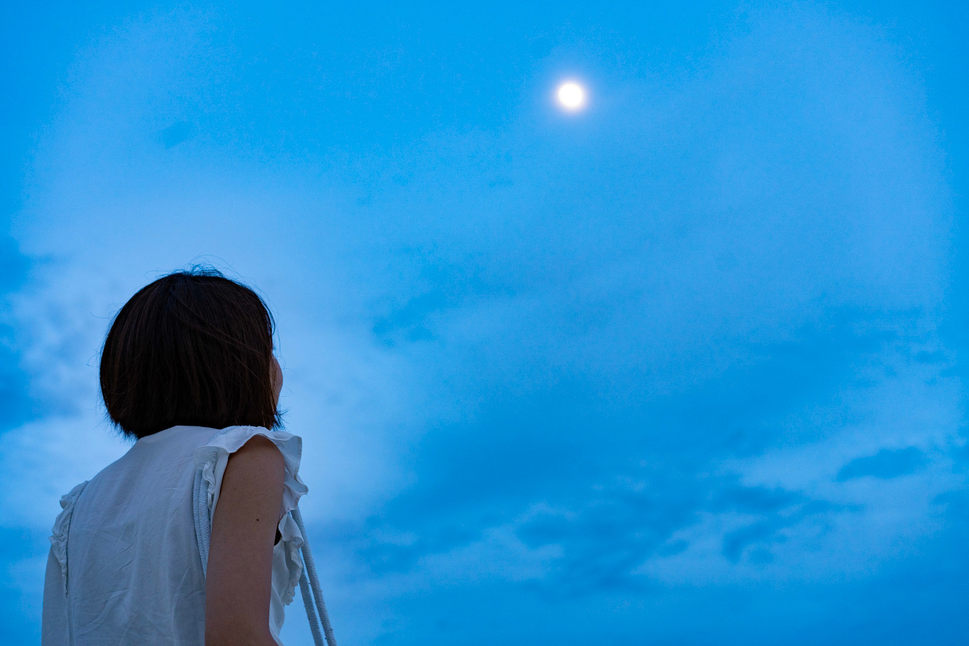 おぼろ月を見上げる女性