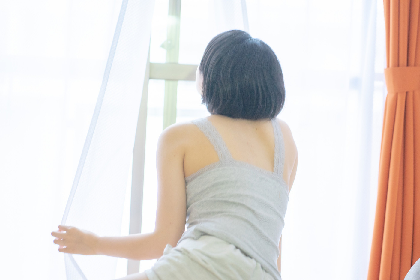 ベットから起き上がる女性