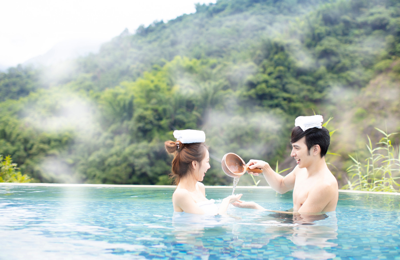 Young asian couple relaxing in hot springs