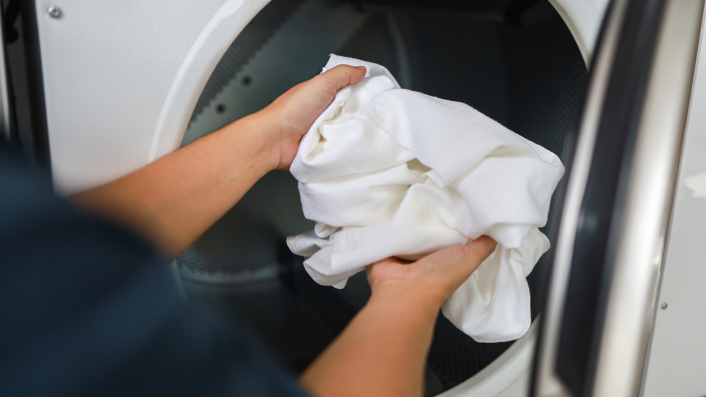 Man doing launder holding basket with dirty laundry of the washing machine in the public store. laundry clothes concept