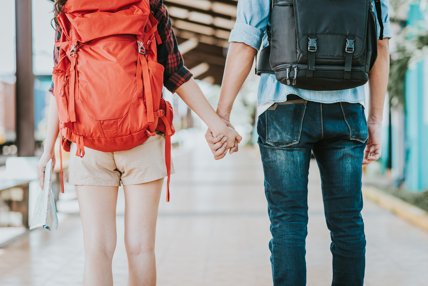 couple backpacker holding hand at train station