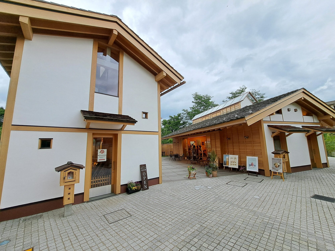 向かって右はカフェ「月の貌」。左は約1万冊の漫画が揃う「漫画堂」。どちらも木の温もりが心地良い空間で、ゆったりとした時間を楽しめる / 1