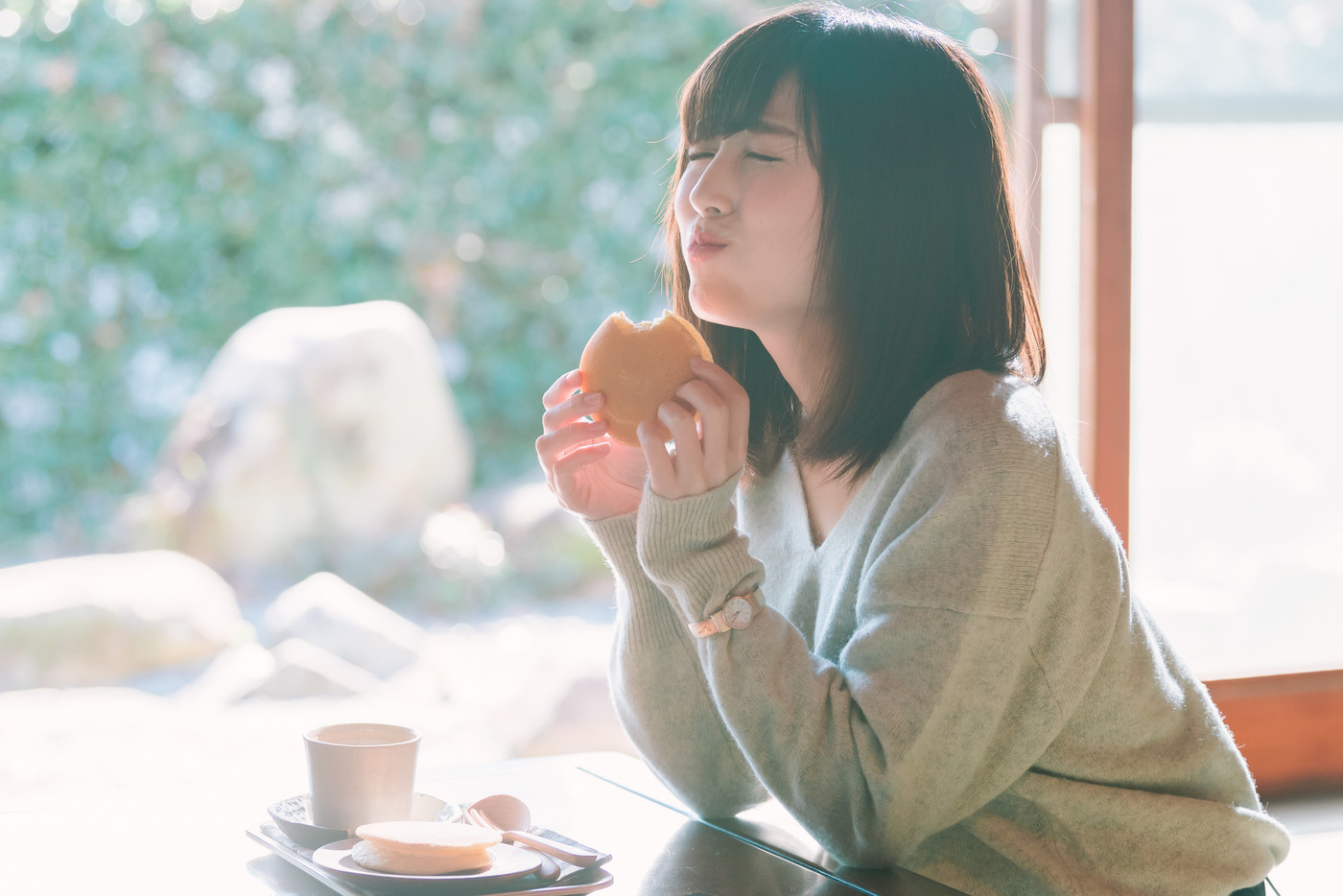 美味しそうにおやつを食べる若い女性