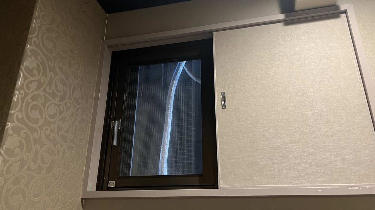 窓からはコンクリートの壁と謎の配管が!!