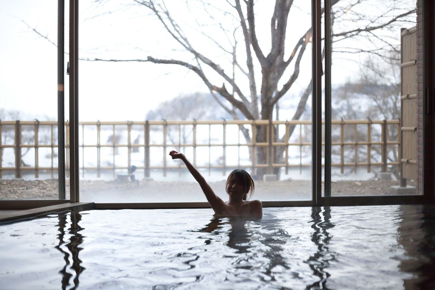 温泉に入りはしゃぐ若い女性