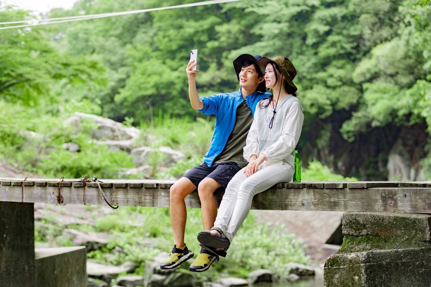 キャンプ場で撮影をする若いカップル