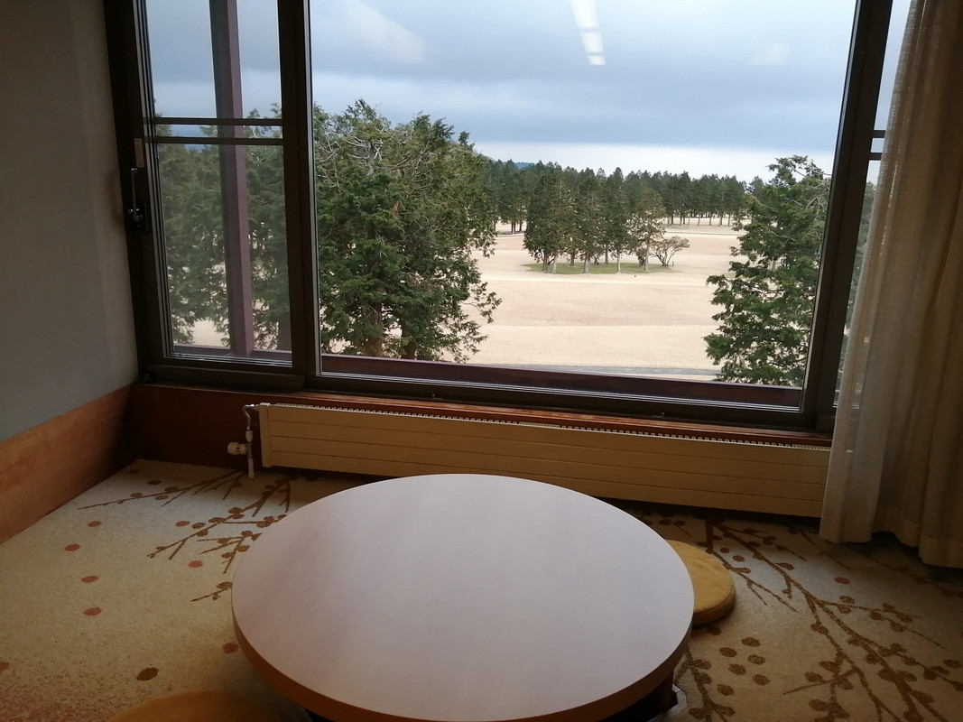 窓際のほりごたつと屋外のゴルフ場