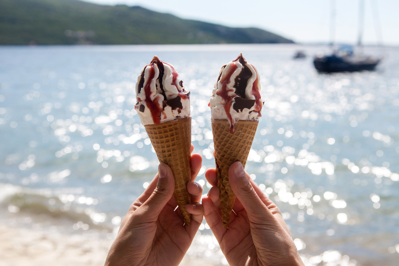 two ice cream cones with chocolate and jam in a