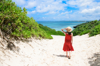 Woman walking on the road leading to the sea