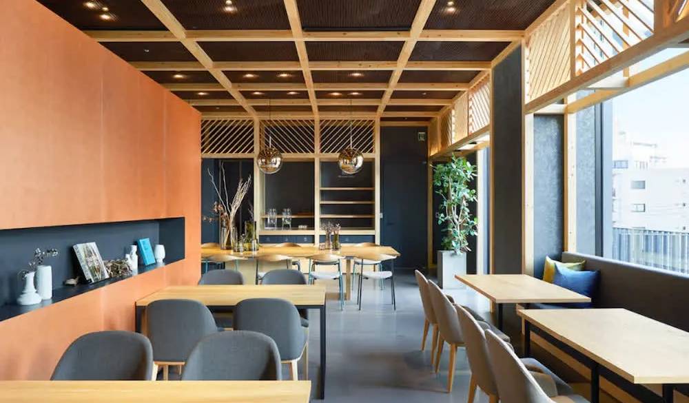 カウンター席やテーブル席があるカフェ。大きな窓から自然光がたっぷり入り明るい雰囲気です。窓の下をのぞき込むと都電が走っているのが見えますよ。