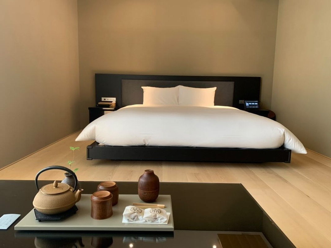 キングベッドを備えた50m²の「Deluxe Room(デラックスルーム)」。素足で歩きたくなる木の床、漆喰風の壁、磨りガラスの窓など、素材感が心地良い。 / 1