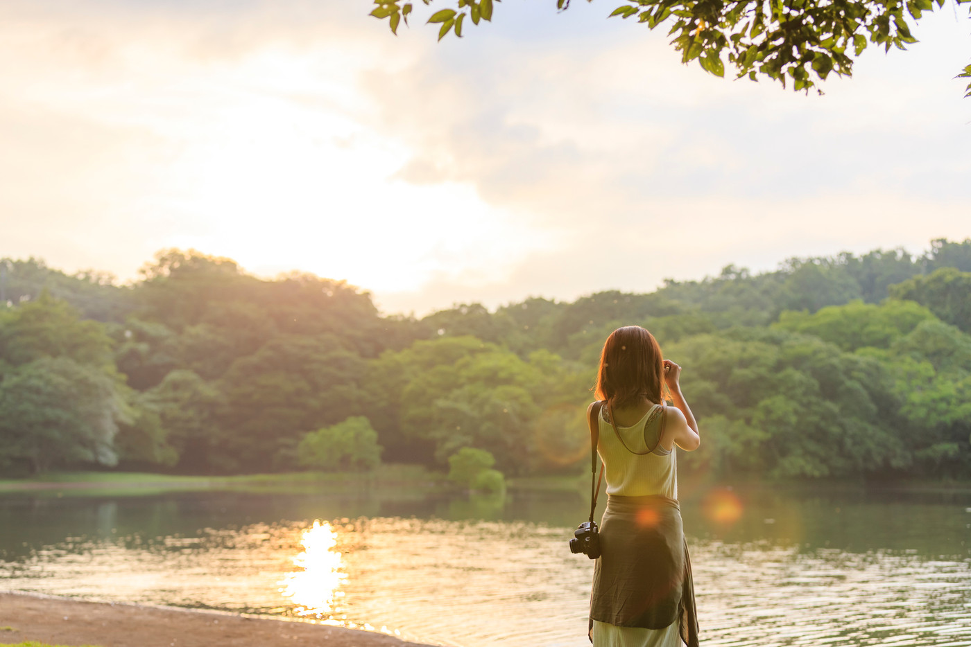 一碧湖の夕暮れと写真を撮る女性