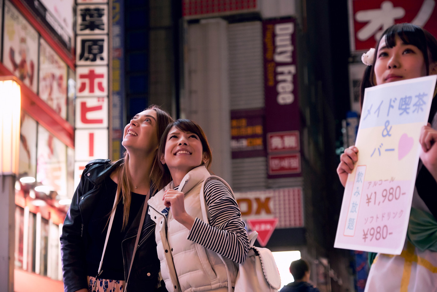 夜の東京を観光する外国人女性と日本人女性