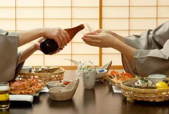 The hand of a woman in a yukata who drinks sake at ryokan