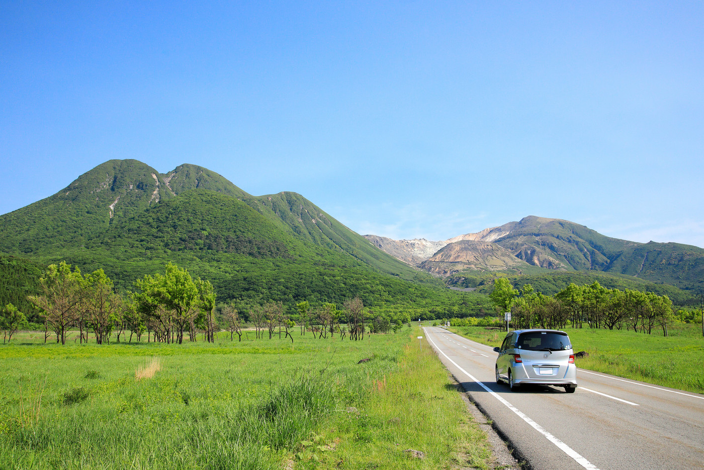 大分県　くじゅう連山を見ながら走る新緑のやまなみハイウェイのドライブイメージ