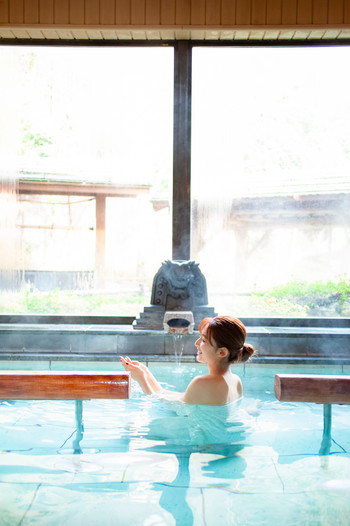 温泉のお風呂を楽しむ女性