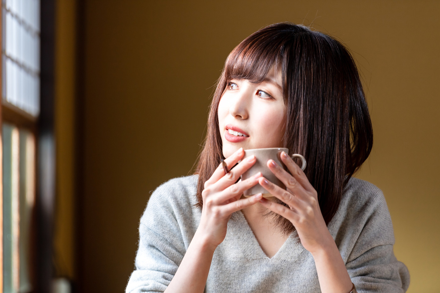 古民家でコーヒーを飲む若い女性