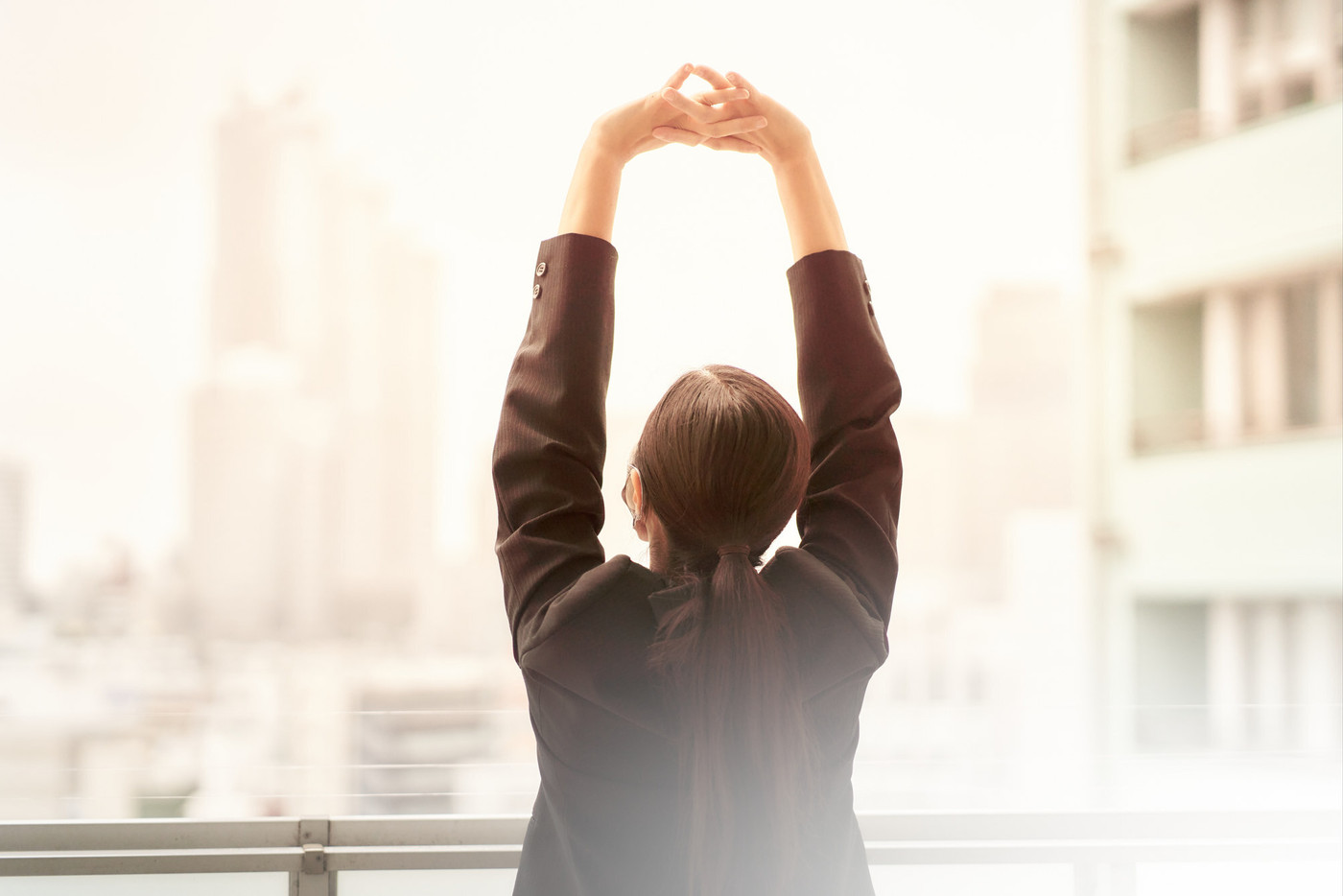 伸びをする女性の後ろ姿