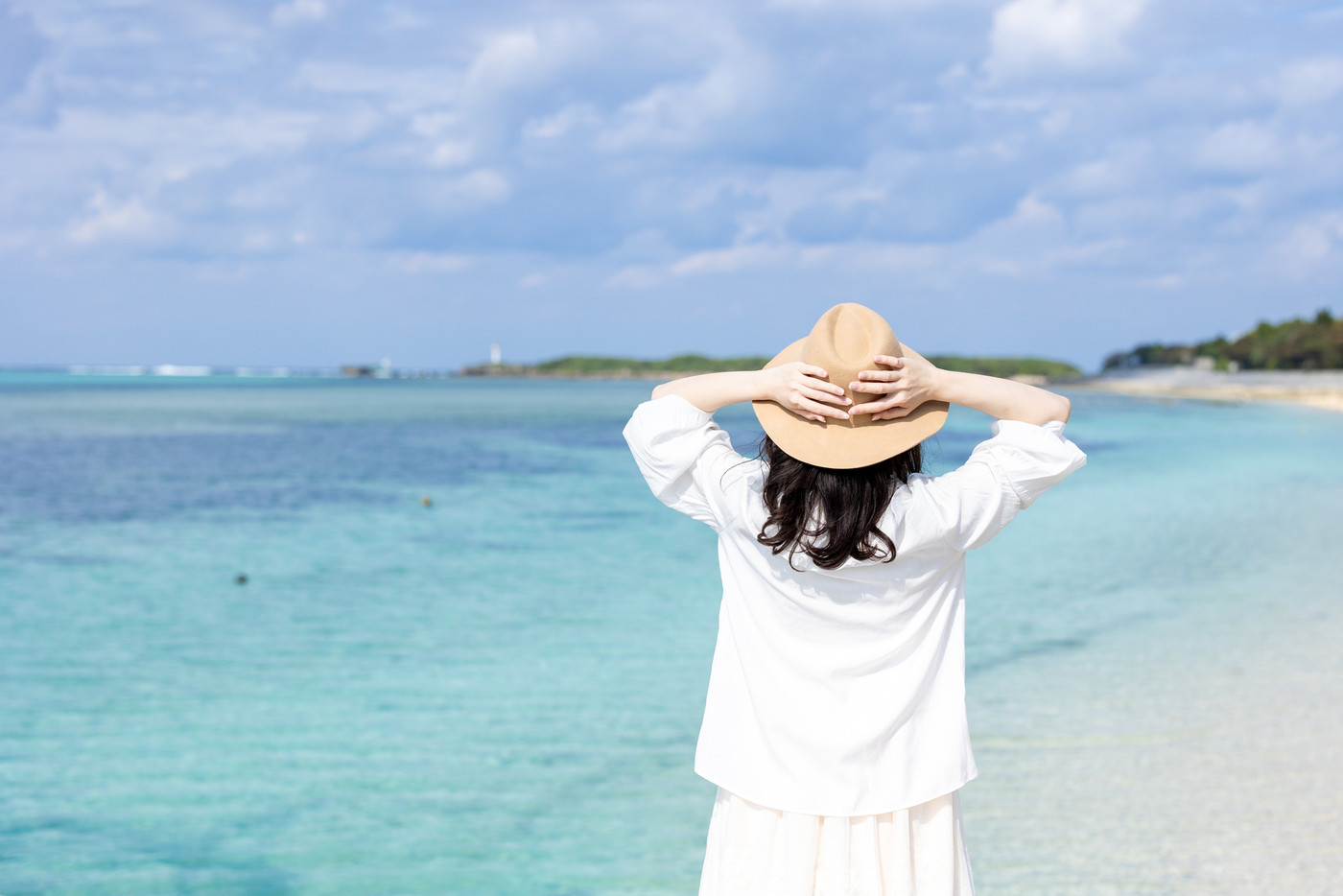 沖縄本部の海岸を散歩する女性
