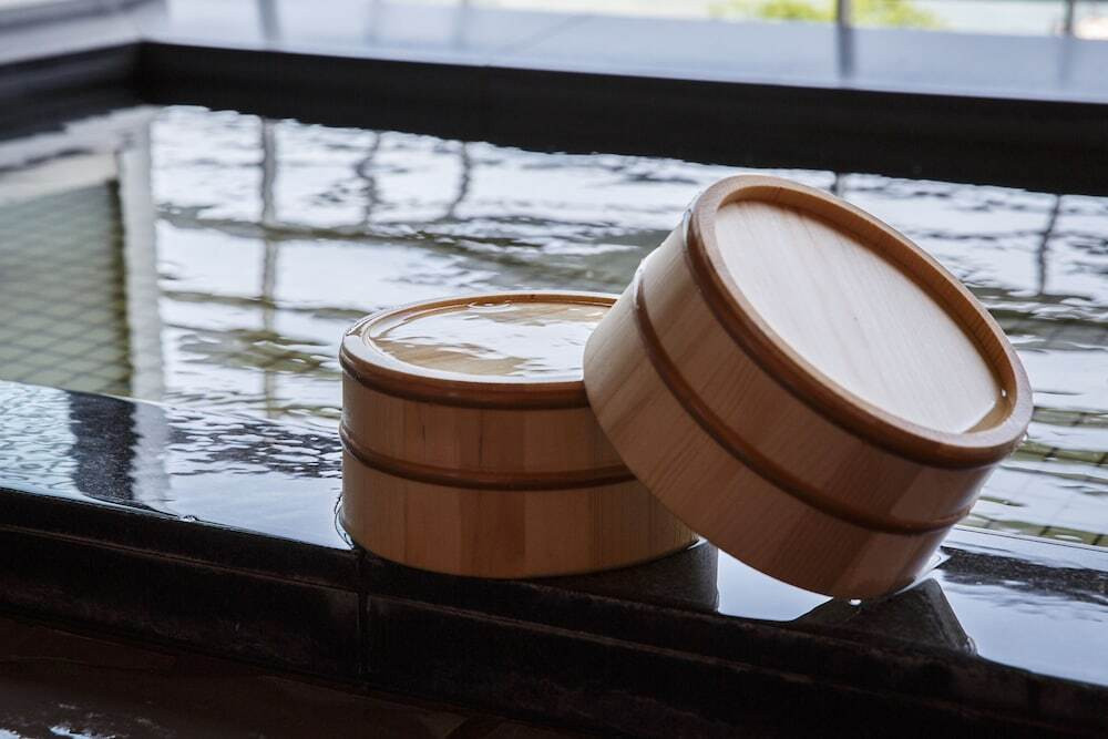 湖と鳥居を見つめる女性旅行者