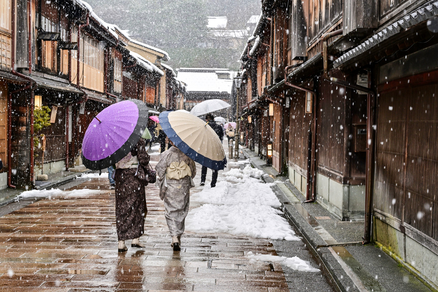 雪が舞うひがし茶屋街を散策する着物女子