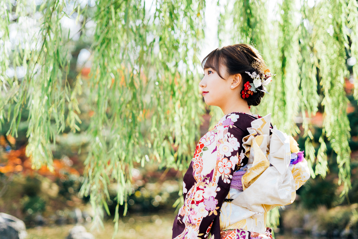 柳の木の下に立つ着物(振袖)の女性