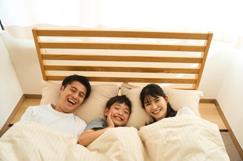 Family sleeping together in bed