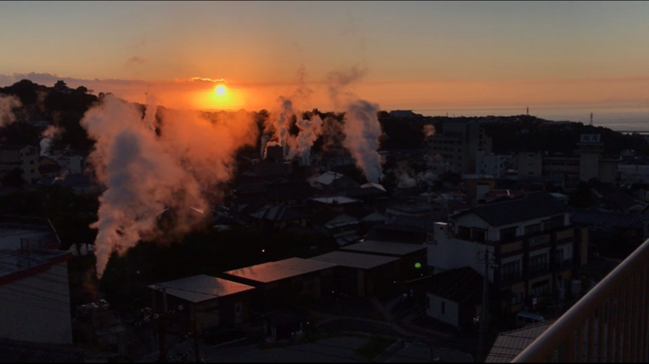 ベランダからの朝焼け　あちこちから立ち上がる湯けむりの町並み