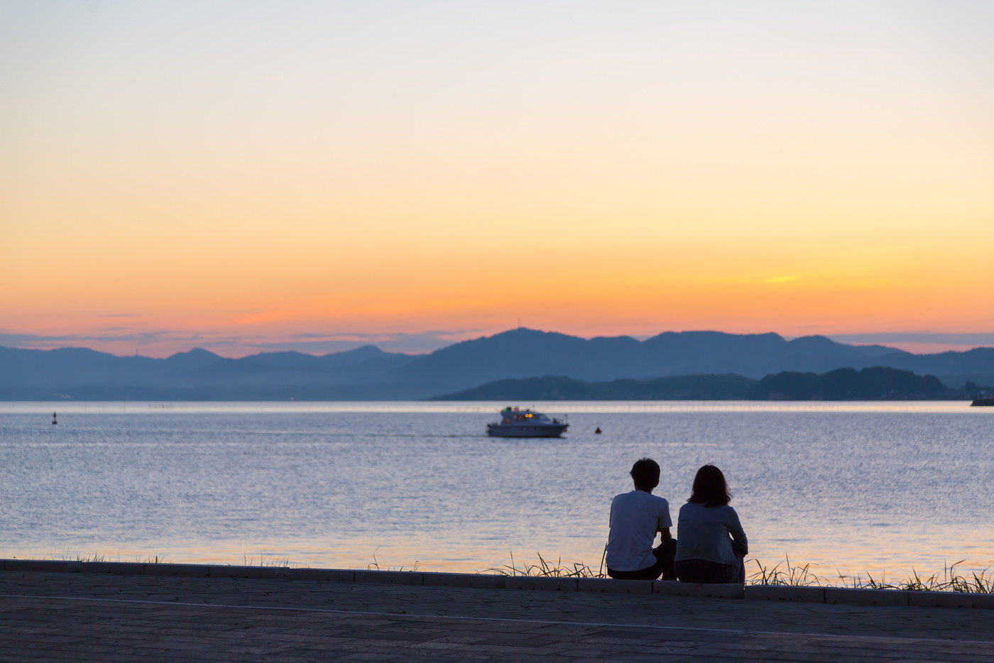 夕暮れの宍道湖を眺めるカップル
