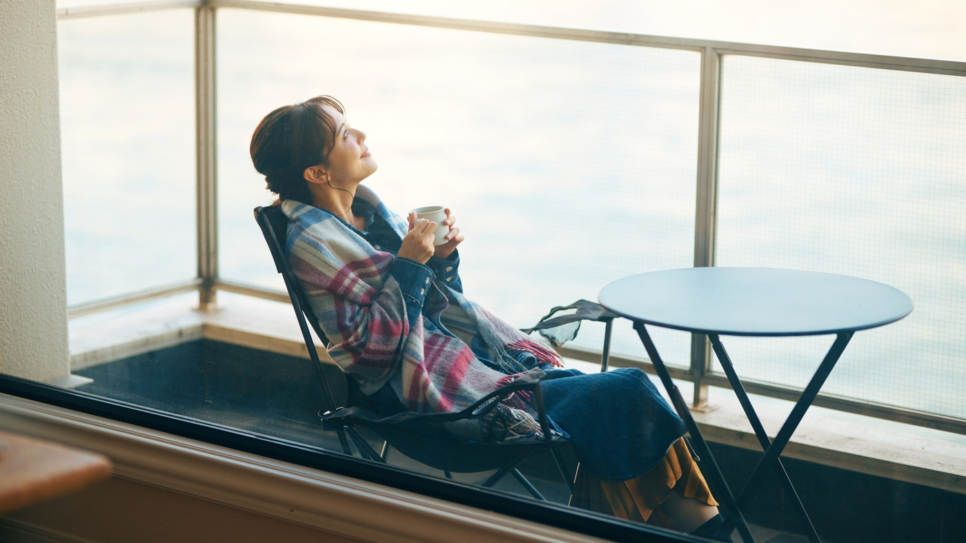 ベランダで優雅にコーヒーを飲む女性