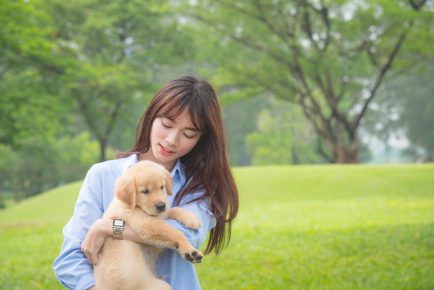 Beautiful girl smiling with her little dog in park