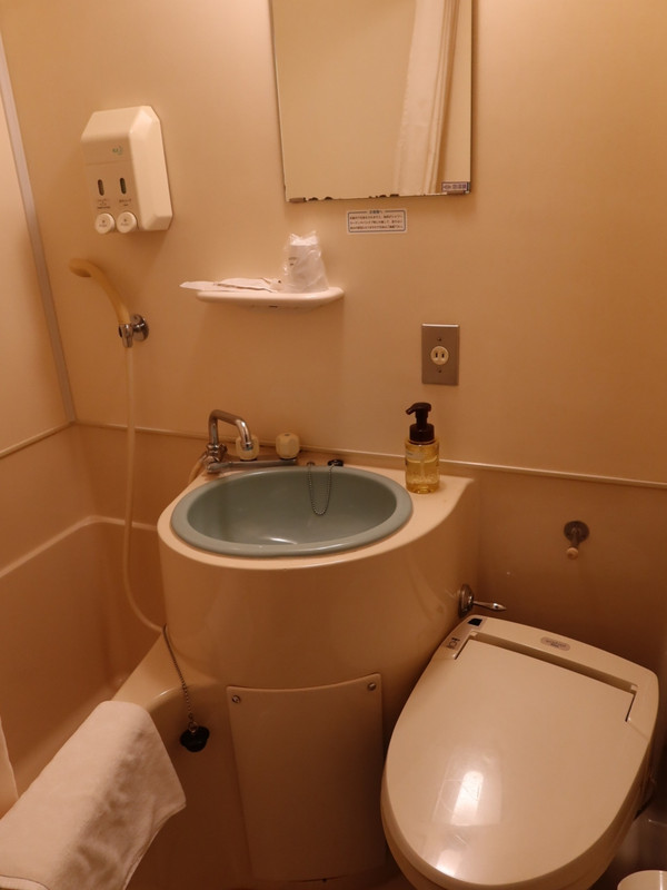 最小クラスの狭さのバスルームで、洗面台まわりに物を置くスペー