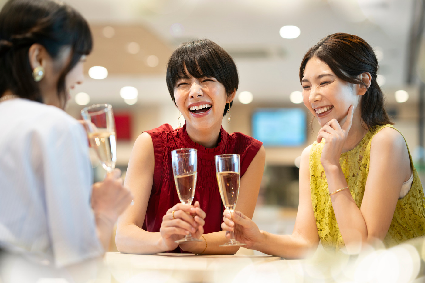 女子会　イメージ　シャンパングラスを持って談笑する若い女性たち　