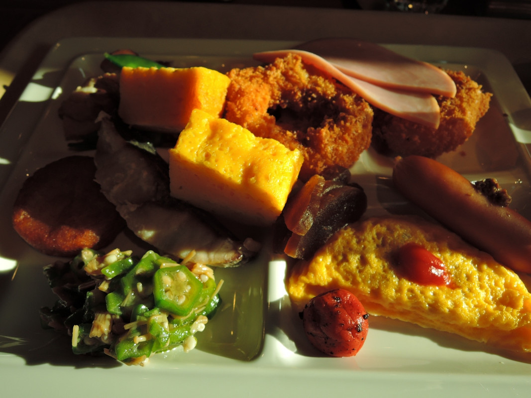 無料の朝食 料理をお皿に盛りつけ