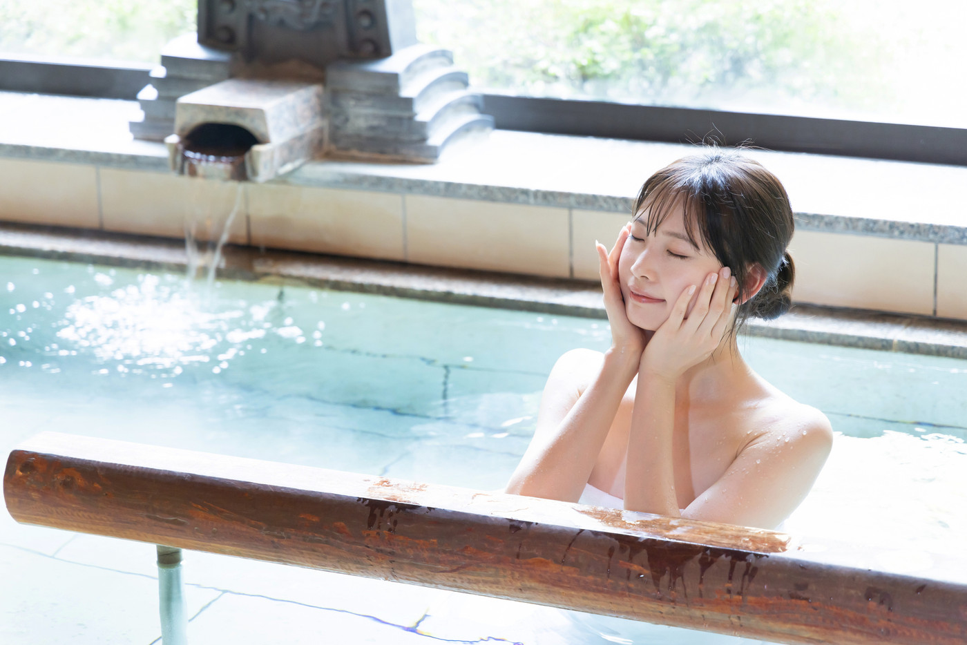 のんびり温泉に入る若い女性