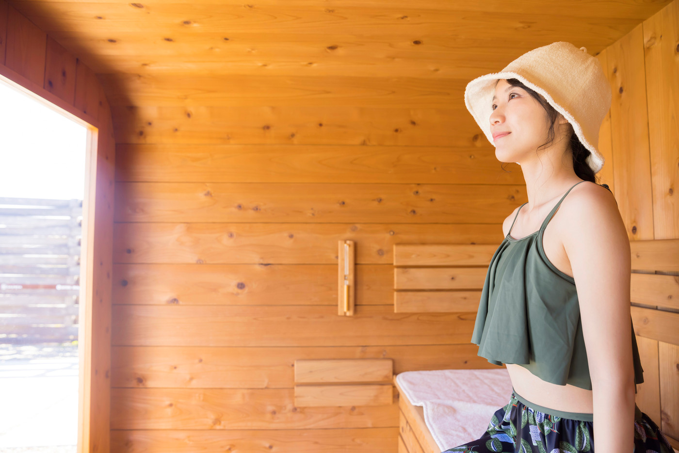 サウナハットをかぶって屋外サウナに入るサウナ女子