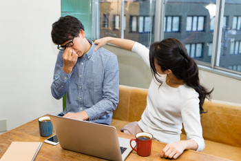 A man and a woman relieve stiff shoulders during work