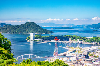 A distant view of downtown Hiroshima. Overlooking Motoujina Park, Ninoshima Island, and the Seto Inland Sea coastline. Take a look at the deep blue sky and sea.