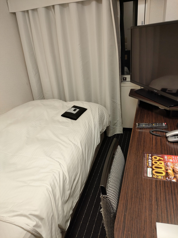 狭い1418号室 机とベッドの間にほとんど空間がない。