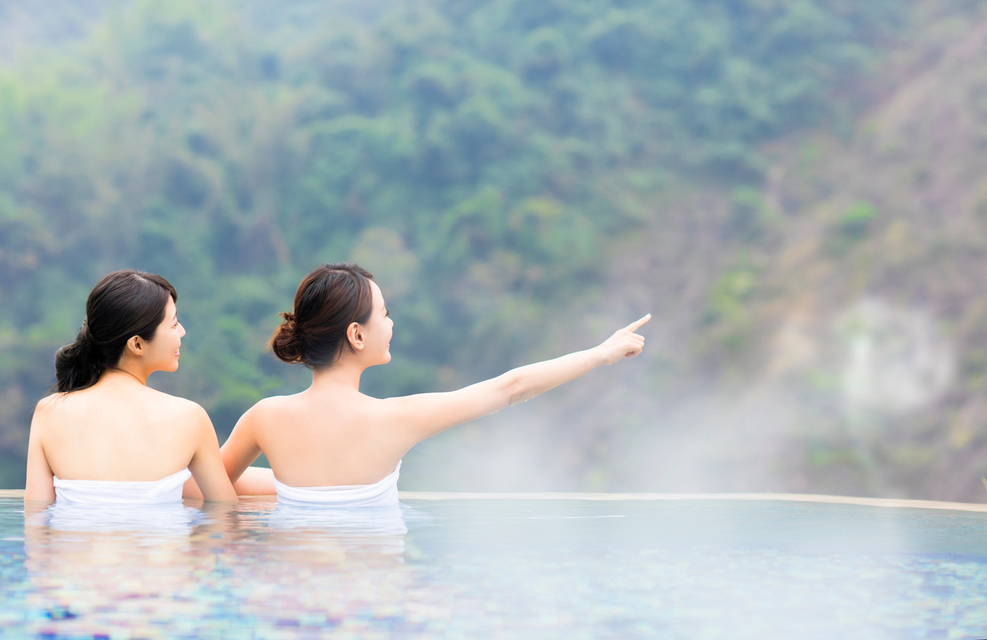 happy young woman relaxing in hot springs
