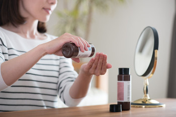 A young woman applying lotion Beauty