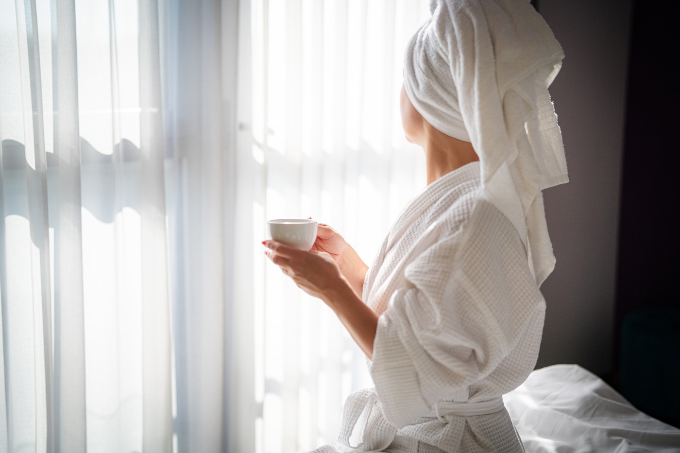 Woman in bathrobe with cup of coffee at home in the morning